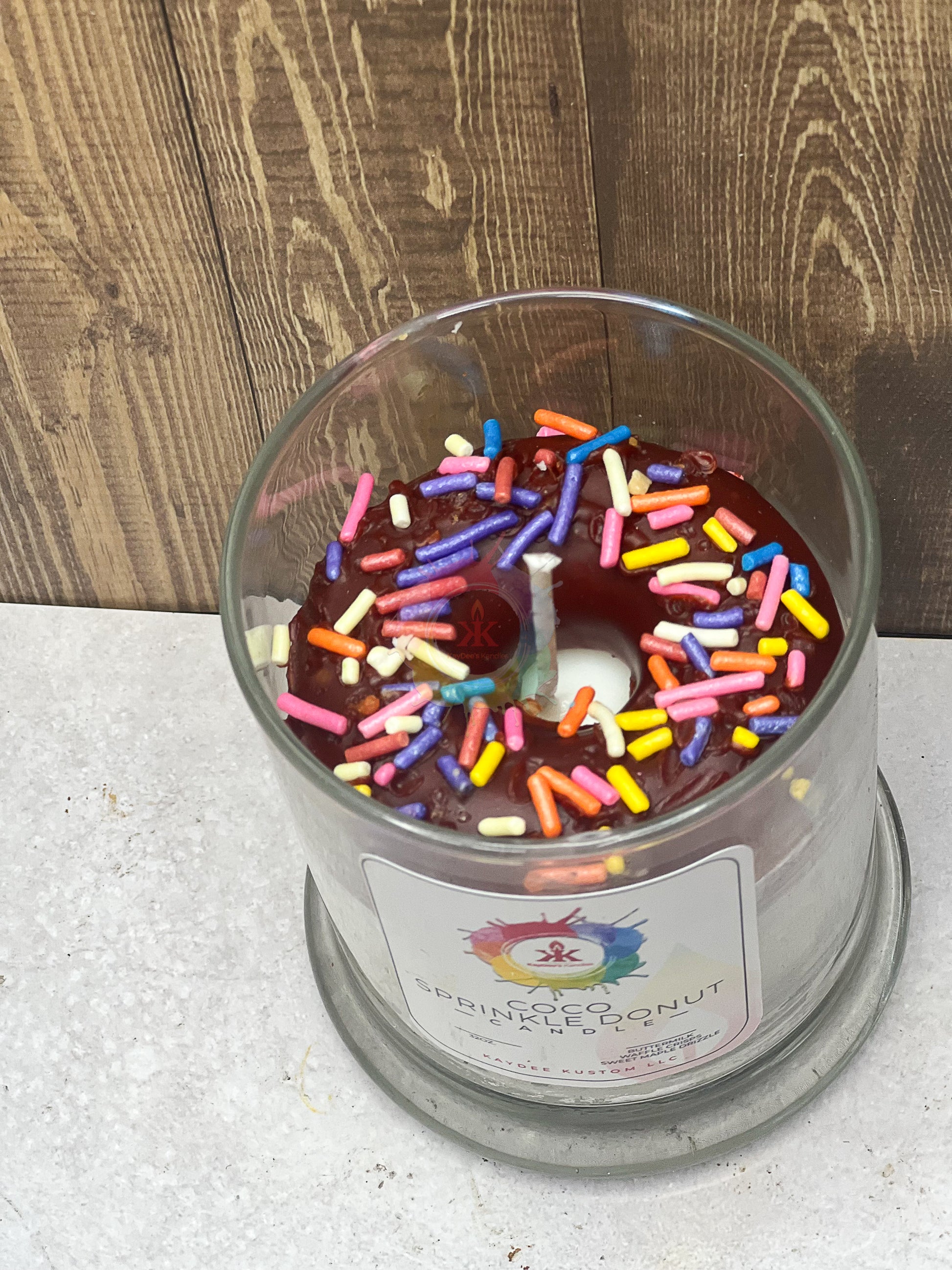 Jar candle donut. Chocolate frosted wax donut with sprinkles in the middle.