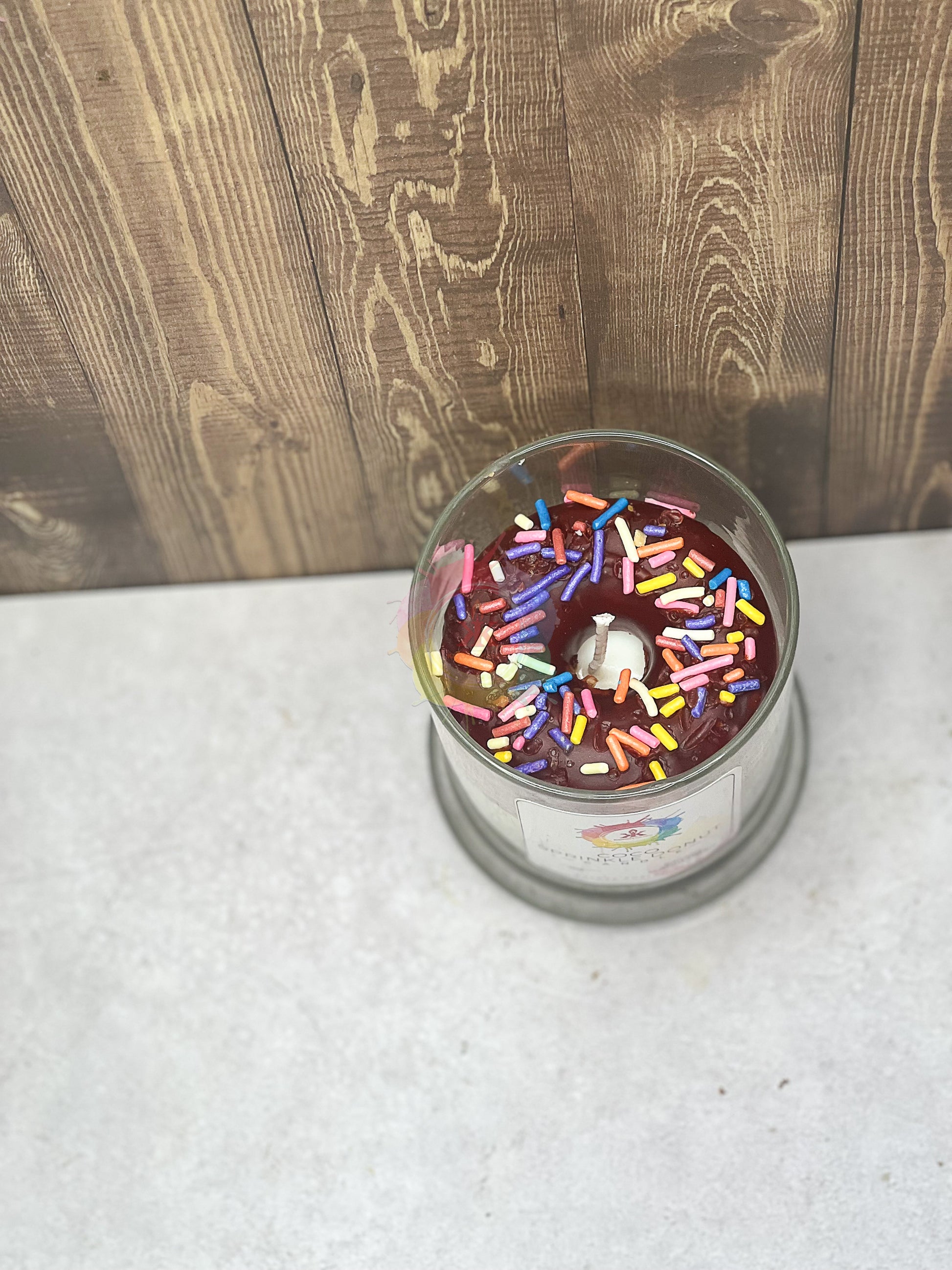 Jar candle donut. Chocolate frosted wax donut with sprinkles in the middle.
