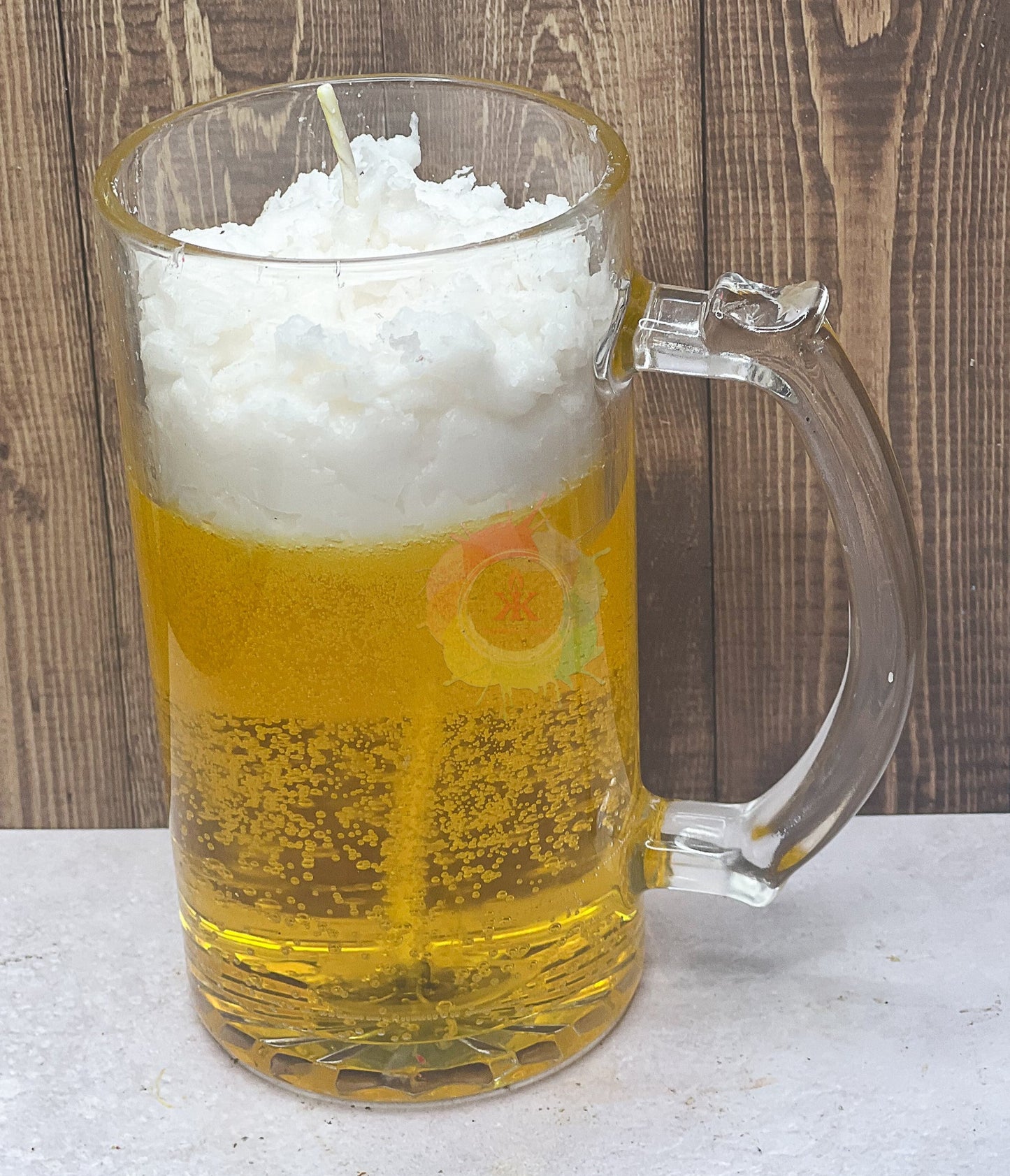 Candle in mug glass jar. Candle made to look like beer with foam on top.